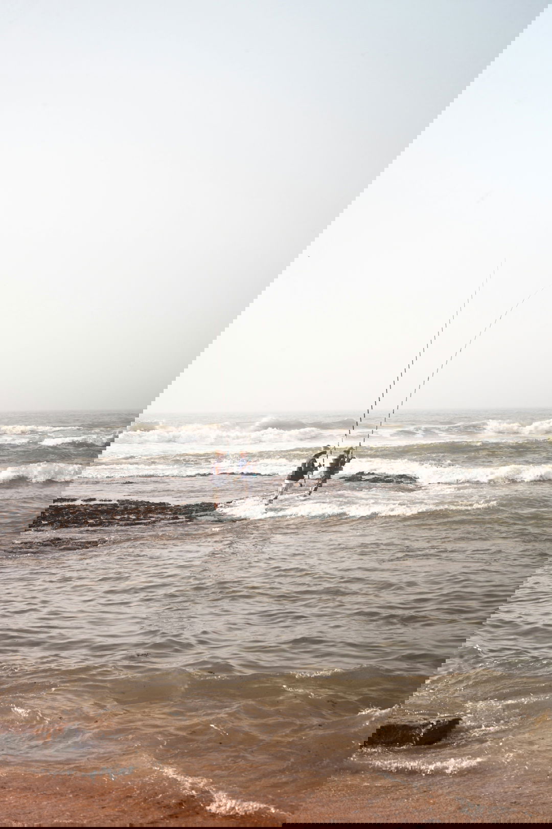 2 person surfing on sea during daytime